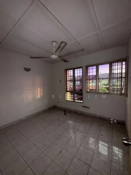 Room features: white painted walls, ceiling fan, tile flooring, three windows with metal grills, natural light from windows, light fixture on ceiling, corner wall with no visible decor, empty room.