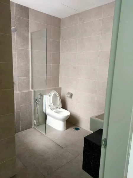 Bathroom features: one-piece toilet, glass shower enclosure, wall-mounted bidet spray, grey tiled walls, light grey floor tiles, built-in bathtub, black countertop, chrome toilet paper holder; style: modern.