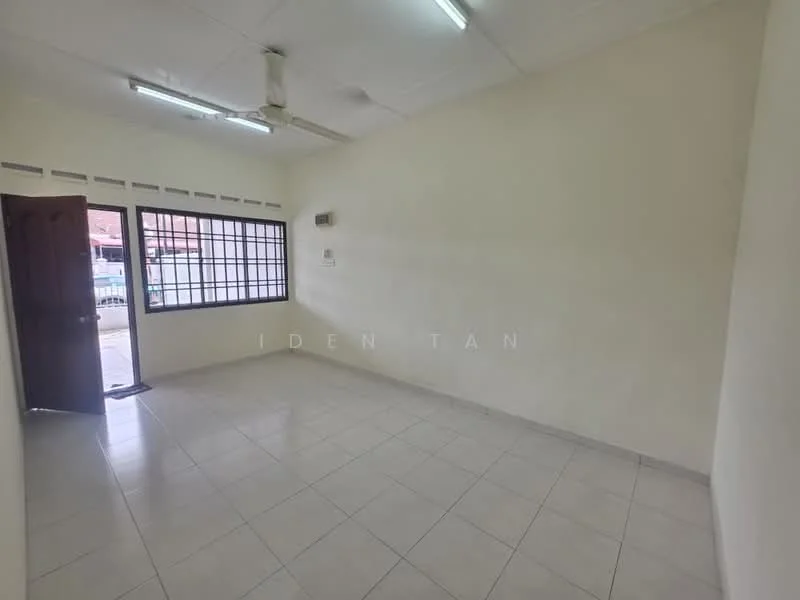 Room features: white painted walls, tile flooring, ceiling with fluorescent lights, window with black grille, single wooden door, air conditioning unit, no visible furniture, empty space.