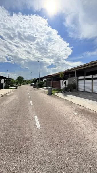 Exterior type: linked terrace house; features: paved road, street lighting, manicured lawns, driveways with interlocking pavers, single-storey houses, surrounded by greenery, clear blue sky, cloudy weather; style: modern.
