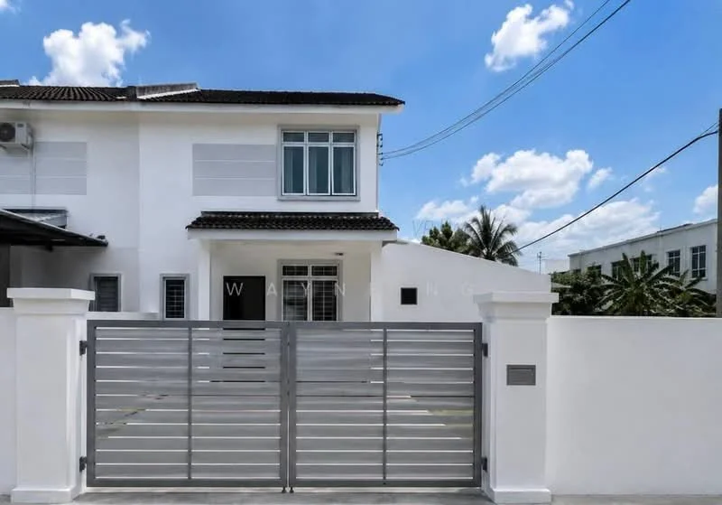 Exterior type: semi-detached house; features: white painted facade, flat roof, two-storey structure, sliding glass windows, metal gate, paved driveway, manicured landscaping, tropical trees, clear blue sky, electricity poles visible; style: modern.