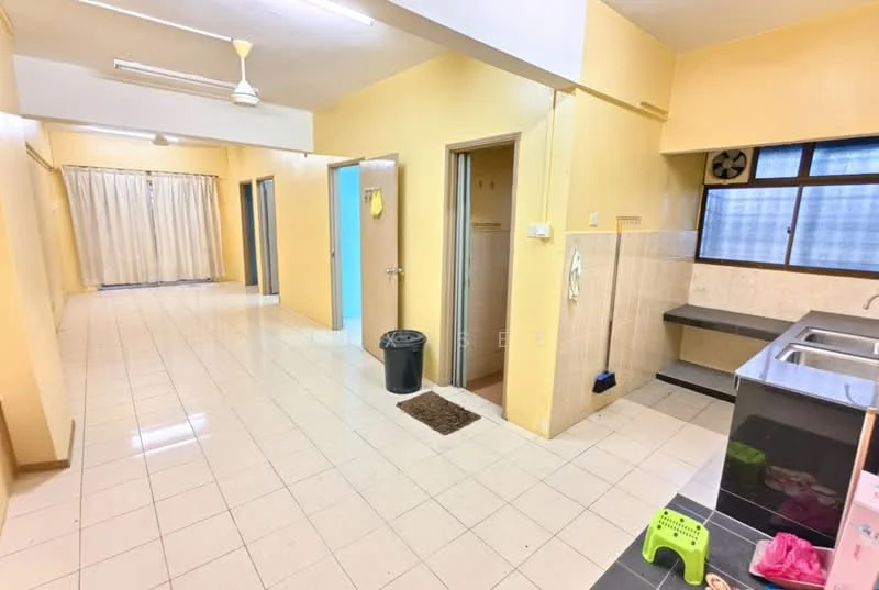 Room features: yellow painted walls, white tiled flooring, ceiling fan, window with blinds, kitchen countertop with sink, black kitchen cabinetry, door to bathroom, door to bedroom, trash bin, small green stool, curtains, light fixture in ceiling.