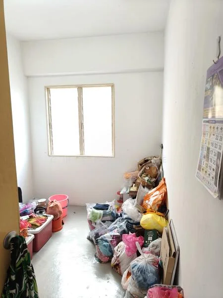 Room features: white painted walls, concrete flooring, single window, various bags and containers, cluttered space.