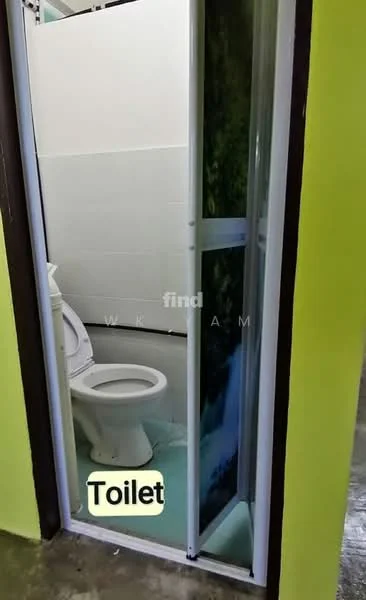 Bathroom features: one-piece toilet, white tiled walls, green accent wall, sliding glass door, flooring with grey tiles, small window, toilet paper holder.