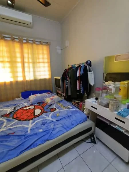 Bedroom features: queen-size bed with blue Spiderman bedding, wooden bedside table, mirror with storage drawers, clothes rack with hanging clothes, window with sheer curtains, wall-mounted air conditioning unit, white tiled flooring, light-colored painted walls.
