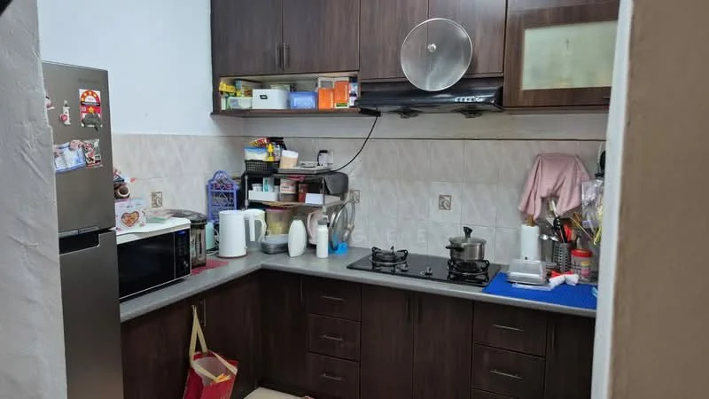 Kitchen features: brown wooden cabinetry, grey countertop, stainless-steel fridge, microwave, kettle, double-burner gas hob, exhaust hood, white ceramic tile backsplash, sink, various kitchen utensils, wall-mounted storage, red shopping bag; style: modern.