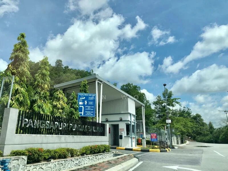 Exterior type: gated community entrance; features: modern entrance gate, security guardhouse, signage with community name, manicured landscaping, paved driveway, surrounding greenery, parking area, security cameras visible; style: modern.