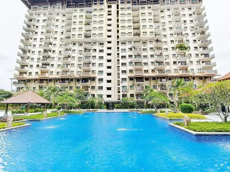 Exterior type: high-rise condominium; features: swimming pool, landscaped garden, manicured lawn, palm trees, tropical landscaping, multiple balconies, glass curtain wall, outdoor pavilion, water features, surrounded by greenery; style: modern.