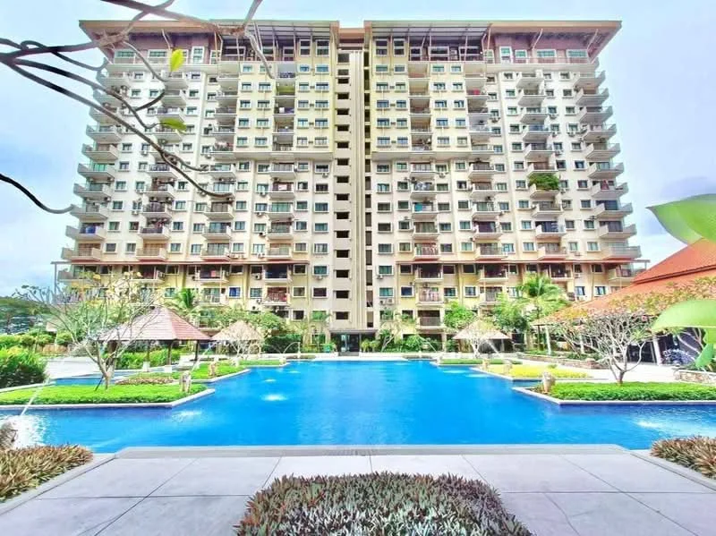 Exterior type: high-rise condominium; features: swimming pool, landscaped garden, manicured lawn, multiple balconies, glass curtain wall, tropical landscaping, paved walkway, outdoor seating areas, water features, surrounded by greenery; style: modern.
