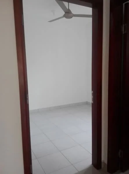 Room features: white painted walls, ceiling fan, light-colored tile flooring, door frame, door, empty space.