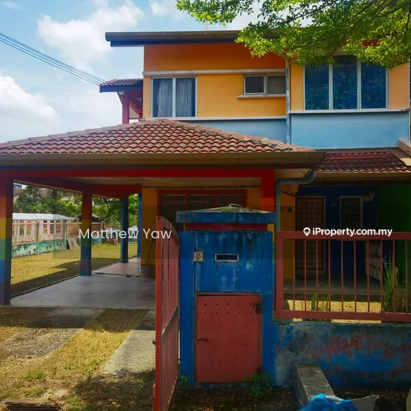Exterior type: semi-detached house; features: two-storey structure, red and yellow painted facade, pitched tile roof, covered car porch, manicured lawn, front garden area, windows with white frames, concrete walkway, fenced perimeter, visible mailbox, outdoor lighting, surrounding greenery; style: modern.