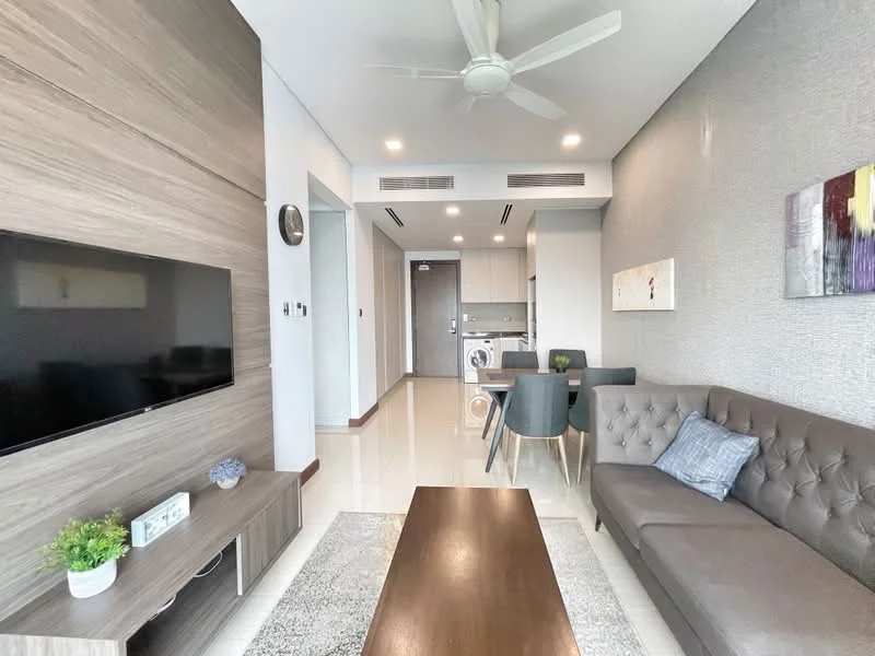 Living features: 3-seater fabric sofa in grey, coffee table, wall-mounted TV, wooden TV console, ceiling fan, recessed downlights, decorative wall art, area rug with geometric pattern, large windows with natural light, open layout to kitchen and dining area; style: modern. Kitchen features: built-in kitchen cabinets, stainless-steel sink, single-bowl stainless-steel sink, chrome pull-down faucet, built-in washing machine, ceramic tile backsplash, refrigerator, 4-burner gas hob, oven, countertop with space for dining; style: modern. Dining features: round dining table, 4 upholstered dining chairs, natural light from windows; style: modern.
