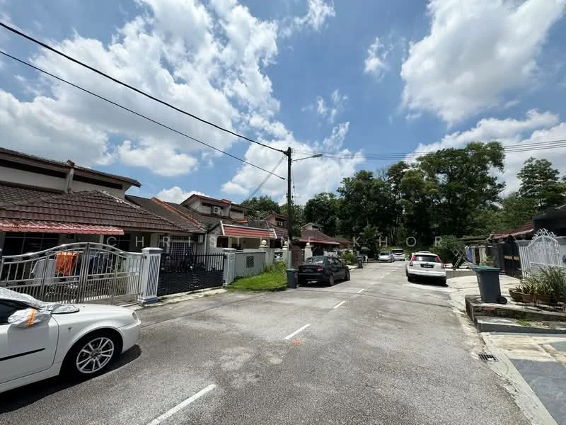 Exterior type: linked terrace house; features: two-storey houses, red tiled roofs, white painted facades, front gardens with grass, driveways for parking, paved walkways, fences around properties, street lighting, mature trees lining the street, clear blue sky; style: modern.