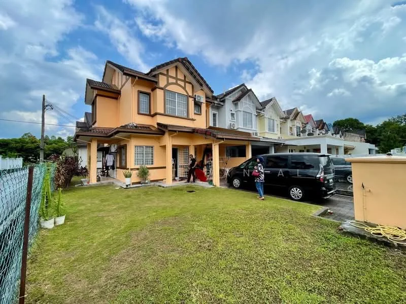 Exterior type: semi-detached house; features: two-storey structure, orange painted facade, pitched tile roof, manicured lawn, driveway with parking space, fenced yard, visible windows with grills, landscaped garden area, adjacent houses in background; style: modern.