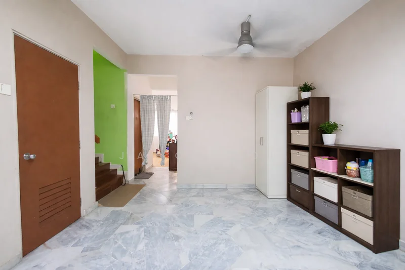 Room features: marble tile flooring, cream painted walls, green accent wall, ceiling fan, wooden storage cabinet, open shelving unit with storage boxes, door leading to another room, staircase visible in background; style: modern.