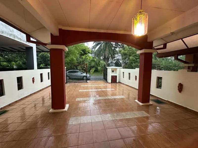 Exterior type: detached bungalow; features: covered porch area, tiled flooring, white painted walls, red accent columns, outdoor lighting fixture, manicured landscaping, paved driveway, gated entrance, surrounded by greenery; style: modern.