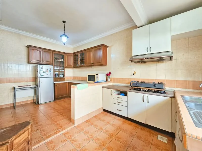 Kitchen features: brown wooden cabinetry, white lower cabinets, stainless-steel fridge, built-in oven, gas stove with exhaust hood, double-bowl stainless-steel sink, ceramic tile backsplash, orange ceramic tile flooring, countertop with space for microwave, window above sink, pendant light fixture; style: traditional.