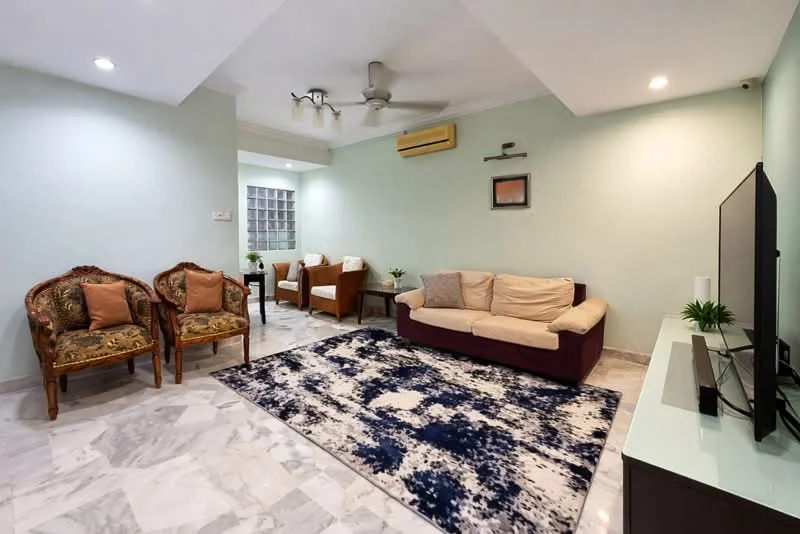 Living features: marble flooring, light green painted walls, ceiling fan with light, sofa in beige, 2 armchairs in brown, TV console, wall-mounted TV, decorative plants, area rug with abstract pattern, recessed lighting; style: modern.