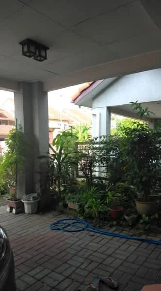 Exterior type: linked terrace house; features: paved driveway, landscaped garden with various plants, overhead light fixture, covered porch area, fence with decorative elements, brick wall, car parked in driveway; style: modern.