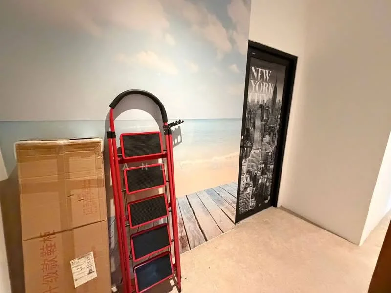 Room features: beach-themed wall mural, light-colored walls, concrete flooring, black door with cityscape design, step ladder, cardboard box; style: modern.