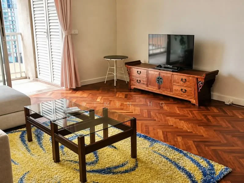 Living features: light wood herringbone flooring, cream painted walls, large window with sliding shutters, beige fabric sofa, wooden coffee table with glass top, wooden TV console, flat-screen TV, decorative area rug with blue and yellow pattern, curtains in light pink, small round side table; style: contemporary; view: city.