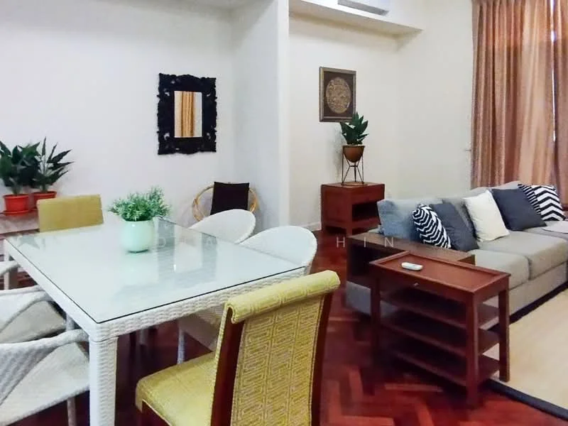 Living features: light wood flooring, cream painted walls, large windows with sheer curtains, sofa in grey fabric, wooden coffee table, glass dining table, 4 upholstered dining chairs in yellow and patterned fabric, decorative wall mirror, indoor plants in ceramic pots, wooden side table, wall-mounted artwork, recessed ceiling lights; style: modern.