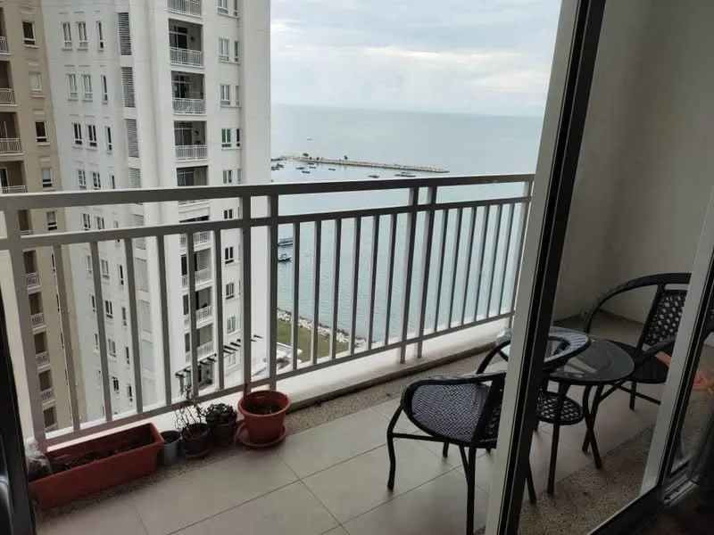 Balcony features: sea view, glass railing, tile flooring, two black wicker chairs, round glass table, potted plants, concrete wall, overhead cover; style: modern; view: sea.