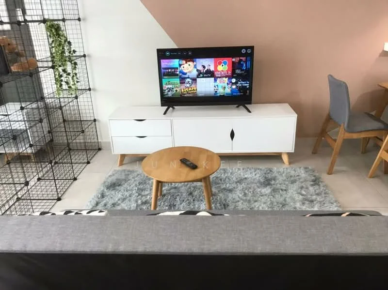 Living features: grey fabric sofa, wooden coffee table, TV console in white, wall-mounted TV, area rug in light grey, decorative plant in wire planter, dining table with grey chairs, light pink accent wall, white walls, wooden flooring, remote control on coffee table; style: modern.