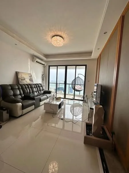 Living features: black leather sectional sofa, white coffee table, wall-mounted TV, glass sliding door, floor-to-ceiling windows, chandelier with crystal design, air conditioning unit, decorative wall paneling, light-colored tiled flooring, hanging rattan chair, decorative sculpture, natural light from windows; style: modern; view: sea.