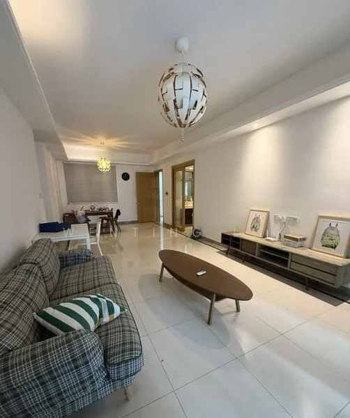 Living features: grey plaid fabric sofa, wooden coffee table, white tiled flooring, recessed downlights, decorative pendant light, framed artwork on wall, built-in shelving unit, window with blinds, dining area visible in background; style: modern.