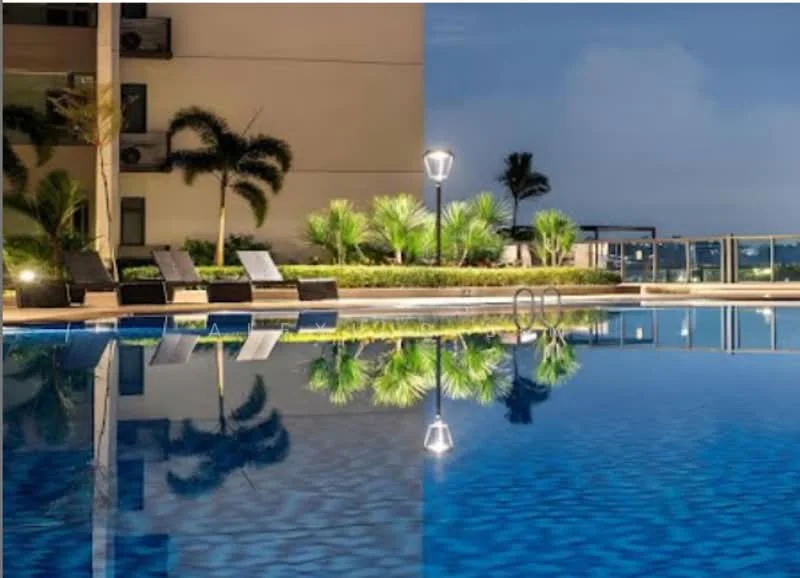 Exterior type: swimming pool deck; features: infinity pool, pool deck with loungers, landscaped garden with palm trees, outdoor lighting, reflections in water, surrounding greenery; style: modern.