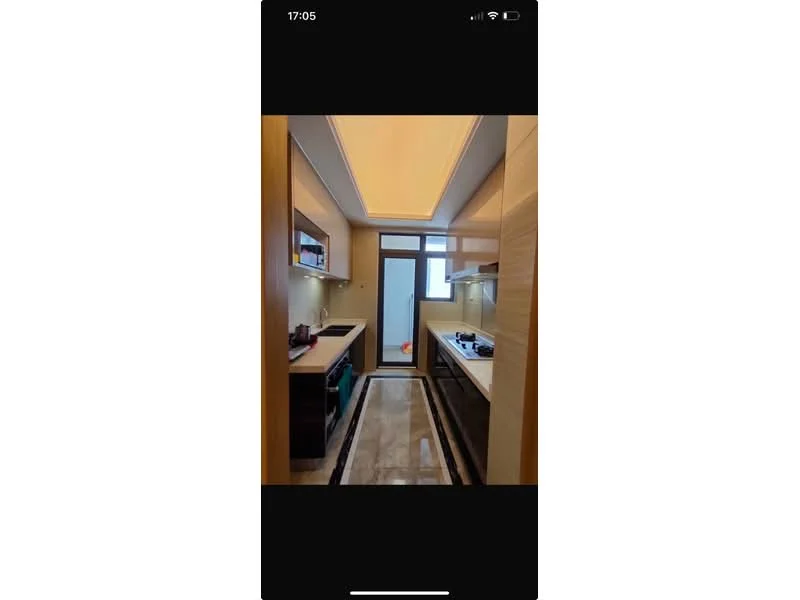 Kitchen features: light wood cabinetry, black countertop, built-in oven, gas hob, stainless-steel sink, chrome faucet, recessed ceiling lights, sliding glass door, marble tile flooring, wall-mounted shelves, window with city view; style: modern; view: city.