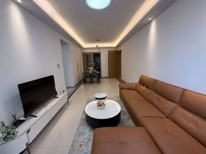 Living features: L-shape brown leather sofa, round marble coffee table, wall-mounted TV, white TV console, recessed ceiling lights, tray ceiling, light grey painted walls, white tiled flooring, dining area visible in background, decorative plant on console; style: modern.