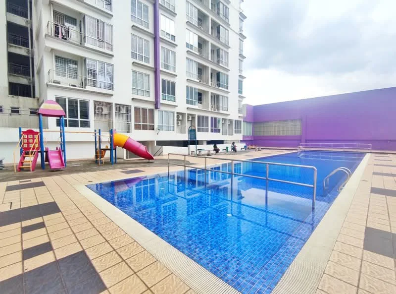 Exterior type: high-rise condominium; features: infinity pool, children's playground with slide, swimming pool deck with loungers, tiled pool area, surrounding landscaping, purple accent wall on building, multiple levels of the building visible, safety railing around pool; style: modern.