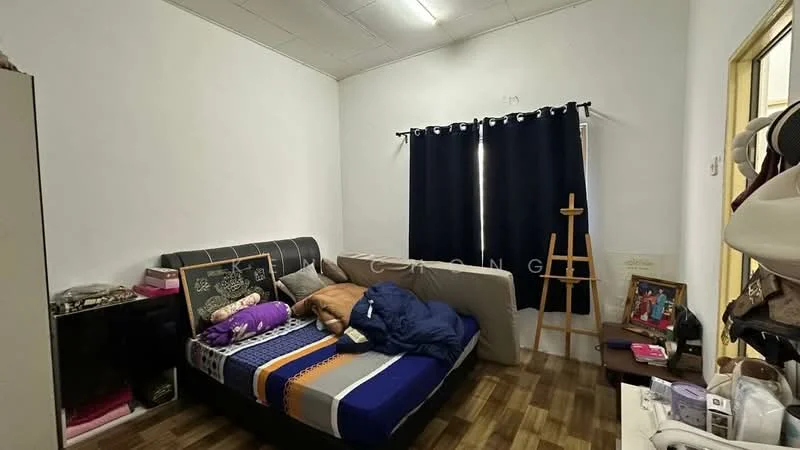 Bedroom features: queen-size bed with patterned bedding, black upholstered headboard, wooden flooring, white painted walls, blackout curtains, easel for artwork, framed photo on floor, decorative items on bedside table.