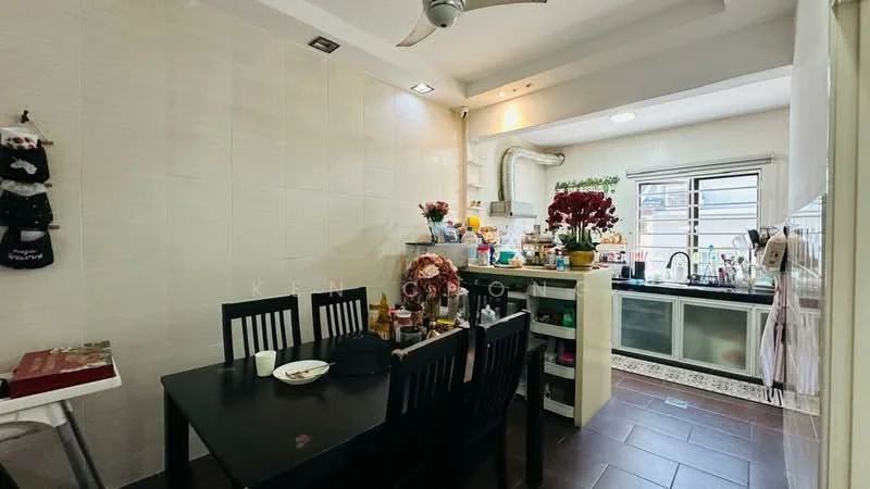 Kitchen features: white tiled walls, dark ceramic tile flooring, ceiling with recessed lighting, 5-blade ceiling fan, black dining table with four chairs, kitchen countertop with sink, stainless-steel sink, chrome pull-down faucet, built-in cabinets with glass doors, microwave, kettle, various kitchen appliances on countertop, window with sheer curtains, decorative plants on countertop; style: modern.