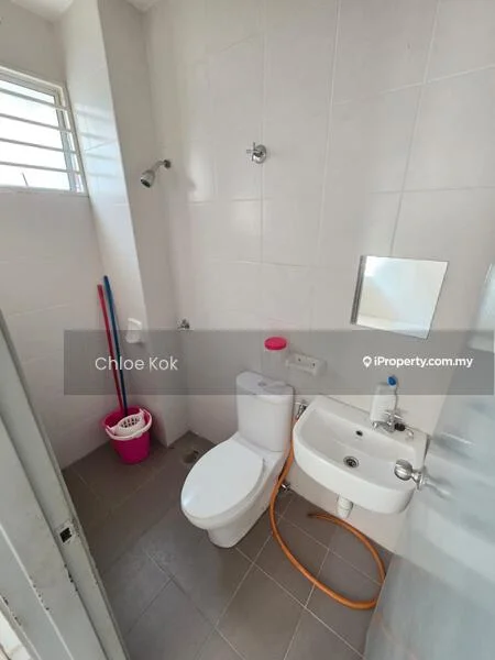Bathroom features: white tiled walls, grey ceramic tile flooring, one-piece toilet, chrome basin mixer, small sink, framed mirror, shower head, shower hose, cleaning supplies, pink bucket.