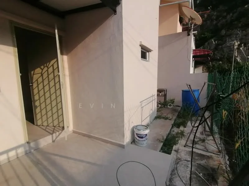 Room features: cream painted walls, grey tiled flooring, door leading to another room, window with view to the outside, fenced outdoor area, concrete pathway, bucket visible, garden area with plants.