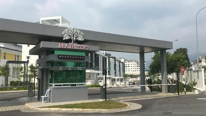 Exterior type: gated community; features: modern entrance gate, signage with 'Majestic', landscaped greenery, paved driveway, security booth, surrounding residential buildings, street signage, curved road layout; style: modern.