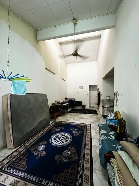 Room features: high ceiling, ceiling fan, marble flooring, light-colored painted walls, large area rug with geometric pattern, dining table, chairs, mattress leaning against wall, sofa, wall-mounted shelves, doorway leading to another room; style: minimalist.