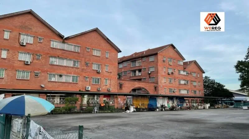 Exterior type: low-rise apartment block; features: red brick facade, multiple storeys, air conditioning units visible on facade, covered parking area, manicured lawn, surrounded by greenery; style: traditional.
