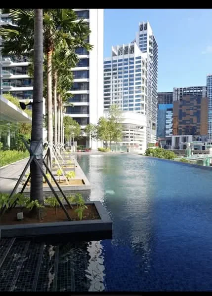 Exterior type: high-rise condominium; features: infinity pool, pool deck with loungers, tropical landscaping, palm trees, glass curtain wall facade, surrounded by modern architecture, manicured garden area; style: modern.