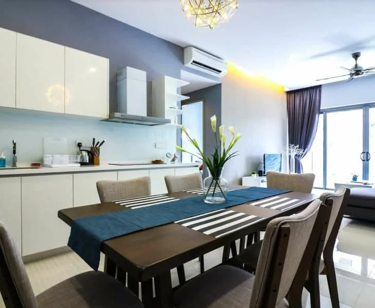 Dining features: 6-seater dining table, wooden dining table with striped runner, upholstered dining chairs, pendant light fixture, wall-mounted split AC, floor-to-ceiling windows, grey accent wall, white cabinetry, stainless-steel kitchen appliances, open shelving, decorative vase with flowers, curtains, light-colored flooring; style: modern. Kitchen features: white cabinetry, stainless-steel range hood, built-in oven, microwave, countertop with backsplash, kitchen utensils visible; style: modern.
