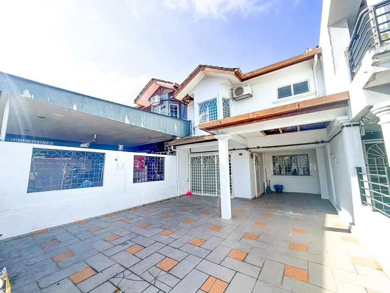 Exterior type: detached bungalow; features: white painted facade, flat roof, paved flooring with decorative tiles, manicured lawn, outdoor space with seating area, windows with metal grilles, air conditioning unit visible, covered car porch, surrounded by low fencing, clear blue sky; style: modern.