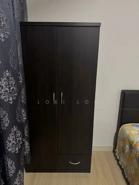Room features: dark wood wardrobe with two doors, single drawer at the bottom, light-colored flooring, grey patterned curtains, bed with patterned bedding.