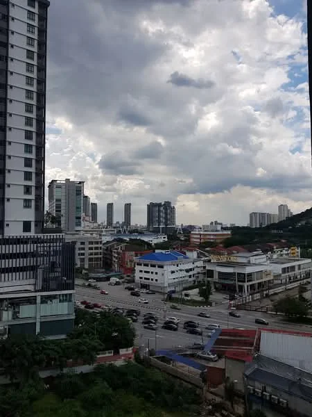 Exterior type: high-rise condominium; features: city skyline view, surrounded by urban development, multiple high-rise buildings, road with traffic, cloudy sky, greenery at the base of buildings; style: modern.