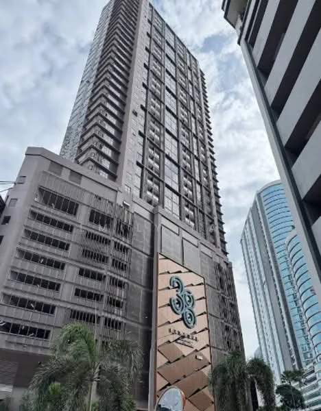 Exterior type: high-rise condominium; features: glass curtain wall, exposed concrete facade, decorative stone cladding, recessed balconies, approximately 30-storey high-rise, surrounded by palm trees, modern architectural design; style: modern.