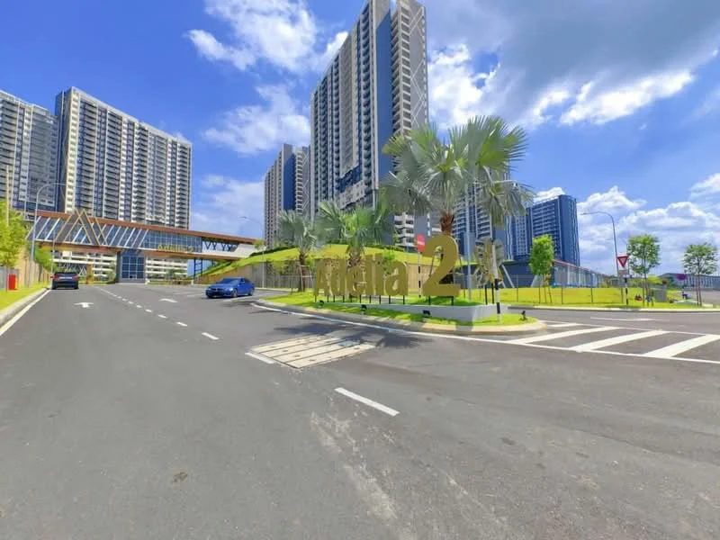 Exterior type: high-rise condominium; features: modern facade with glass and concrete, landscaped entrance with palm trees, wide road leading to the entrance, signage with the name 'Adhara 2', surrounding greenery, multiple high-rise buildings in the background, clear blue sky, well-maintained road surface; style: modern.