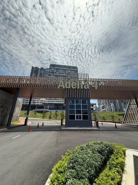 Exterior type: high-rise condominium; features: modern facade with wooden slats, glass entrance, landscaped greenery, paved driveway, surrounding residential buildings, cloudy sky, signage with 'Adelia 21', traffic cones, manicured shrubs; style: modern.