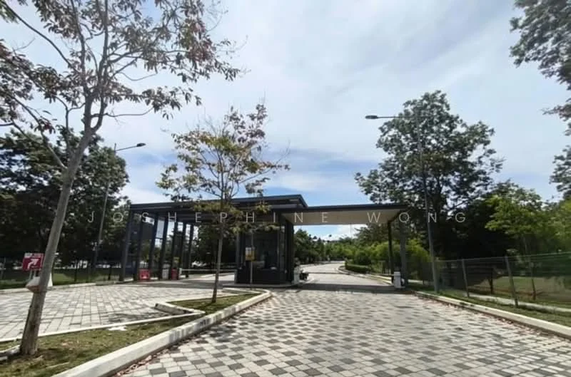 Exterior type: main entrance gate; features: paved driveway, landscaped greenery, trees lining the entrance, security gate, modern architectural design, street lighting, surrounding fencing, clear blue sky; style: modern.